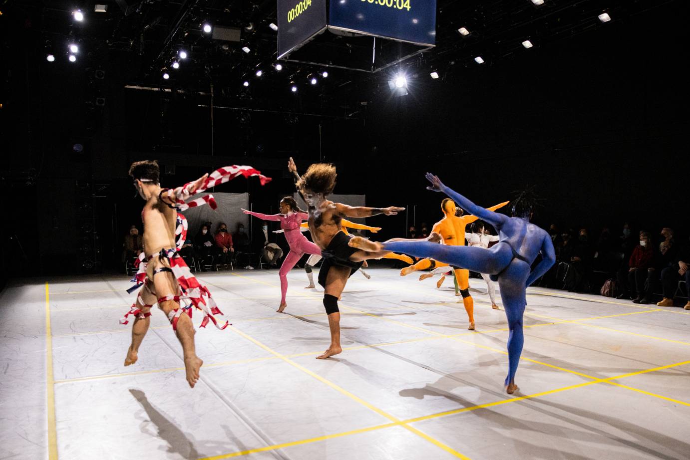 some painted dancers ( appearing nude because of the paint but wearing underclothes) and some dancers not painted but dressed in rags,one set a ripped American flag, jump and kick in the center of the stage and others not painted but dressed in